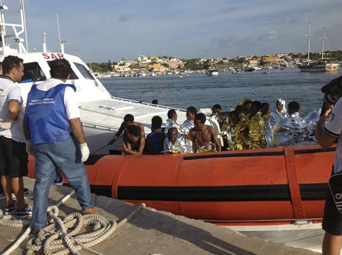 I primi migranti soccorsi sbarcano sull'isola. Reuters